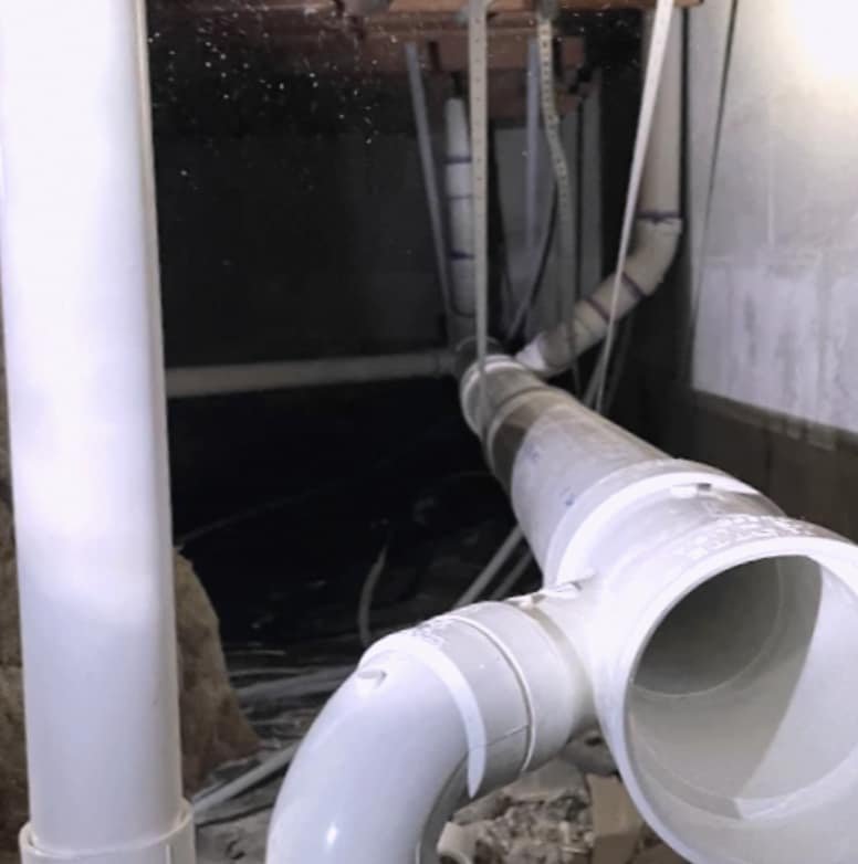 New PVC drain lines installed in a crawlspace